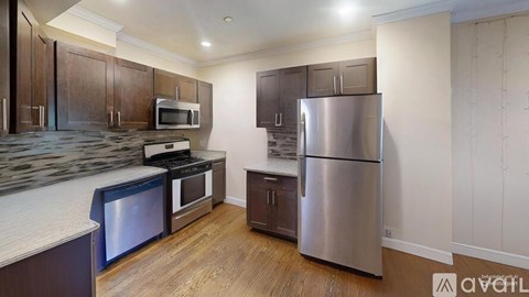 A kitchen with a refrigerator, microwave, oven, and stove.