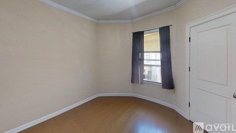 A room with a white door and a window with black curtains.