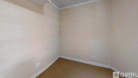 A room with a wooden floor and beige walls.