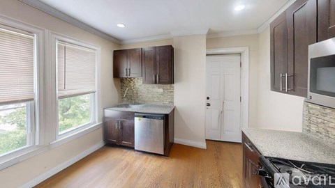 A kitchen with wooden cabinets and a granite countertop.