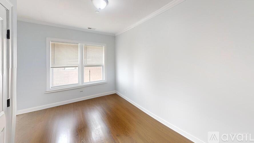 A room with a window and wooden flooring.