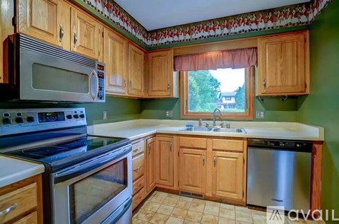 A kitchen with wooden cabinets and a stove top oven.