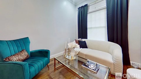 A living room with a teal couch and a white sofa.