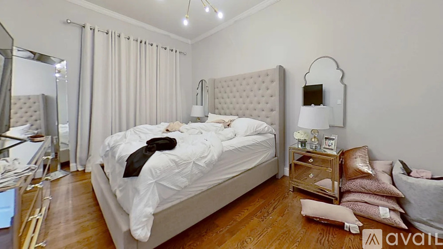 A bedroom with a large bed and a mirror on the wall.