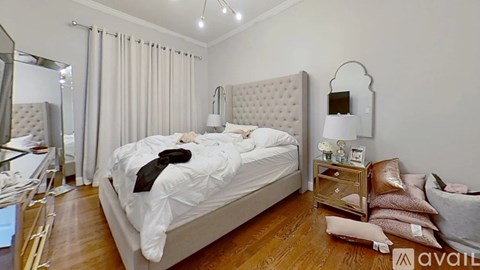 A bedroom with a large bed and a mirror on the wall.