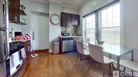 A kitchen with a stove, oven, and a clock on the wall.