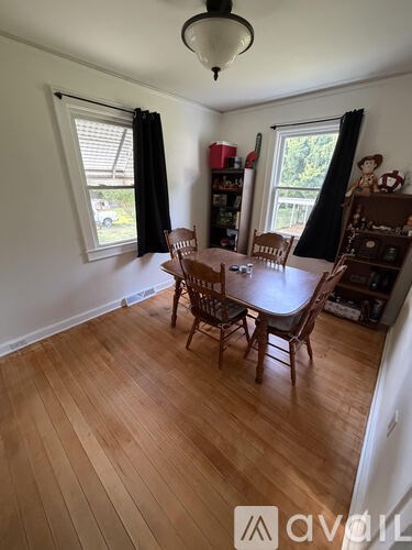 A dining room with a wooden table and chairs.