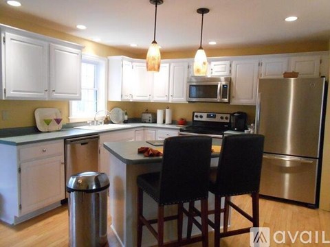 A kitchen with white cabinets and a black countertop.