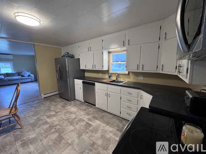 A kitchen with a black countertop and white cabinets.