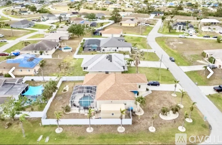A bird's eye view of a residential area with houses and a swimming pool.