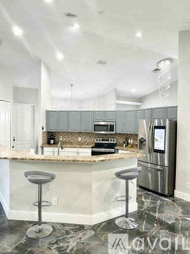 A kitchen with a marble counter top and stainless steel appliances.