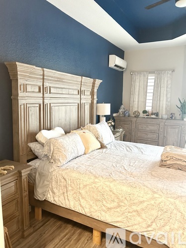 A bedroom with a large bed and a wooden headboard.