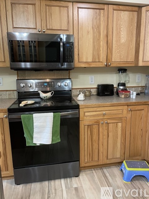 A kitchen with wooden cabinets and a black oven.
