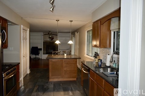 A kitchen with wooden cabinets and a large island.