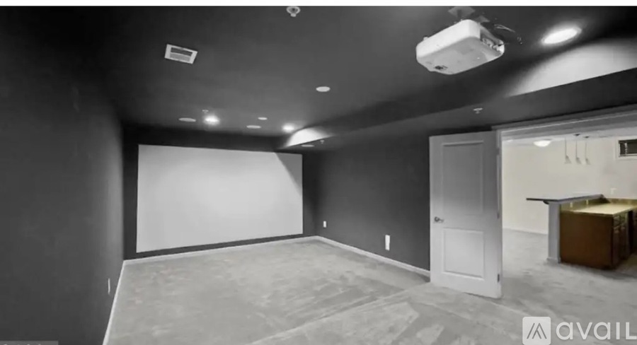 A spacious room with a white screen and a door on the right.