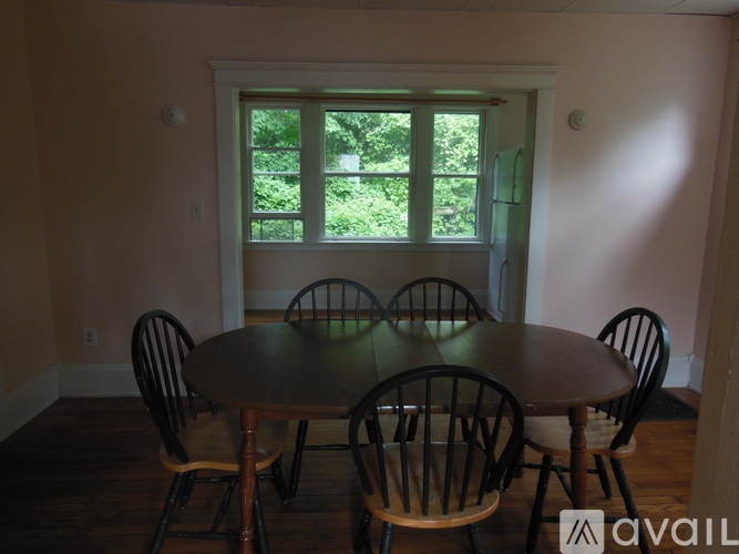 A dining room with a table and chairs.