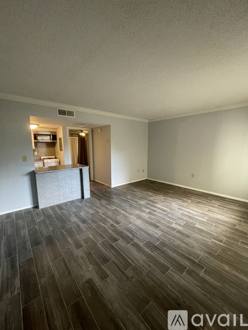A room with a wooden floor and a wall-mounted television.