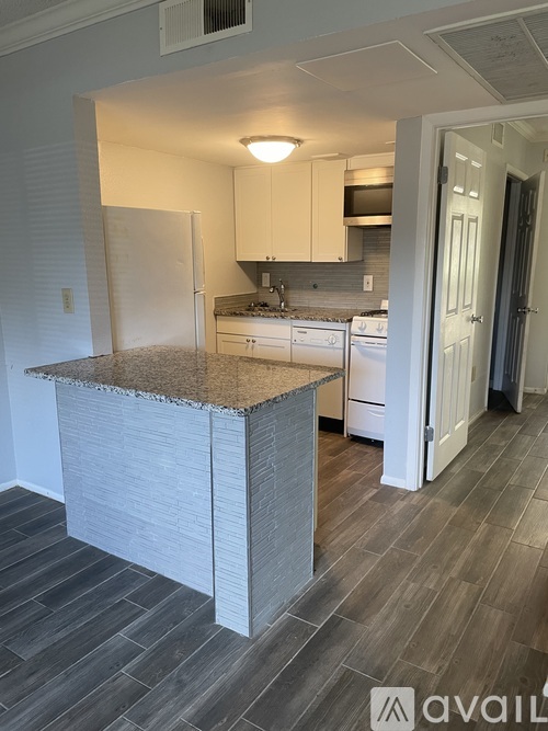A kitchen with a granite countertop and white cabinets.