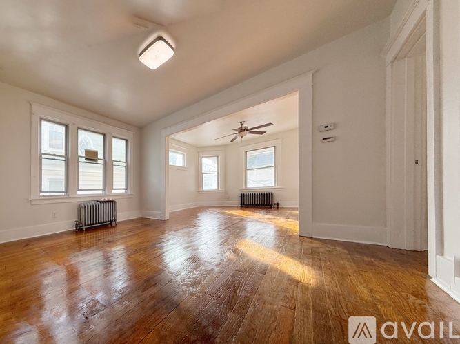 A spacious room with wooden floors and white walls.