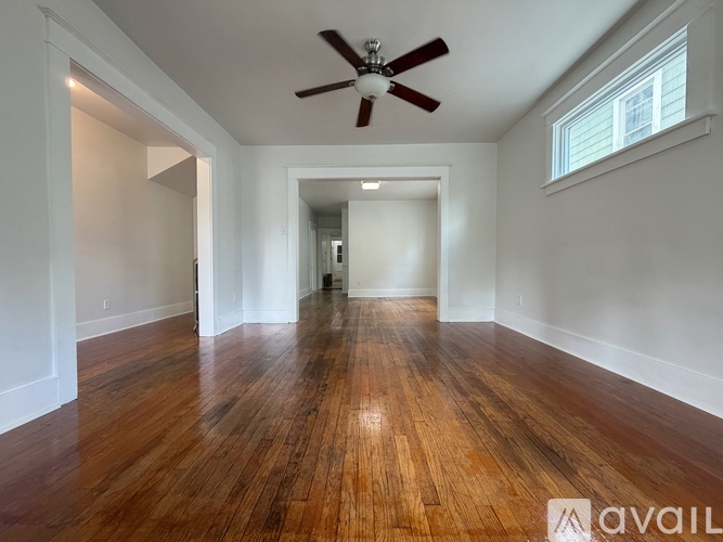 A room with wooden floors and a ceiling fan.