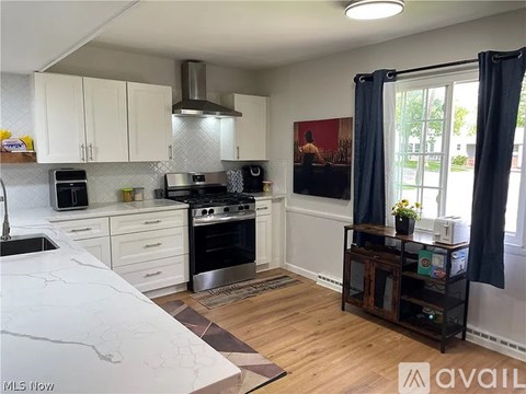 A kitchen with a black stove top oven and a black range hood.