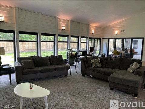 A living room with a grey couch and a white table.