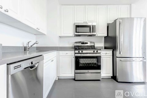 A kitchen with white cabinets and stainless steel appliances.