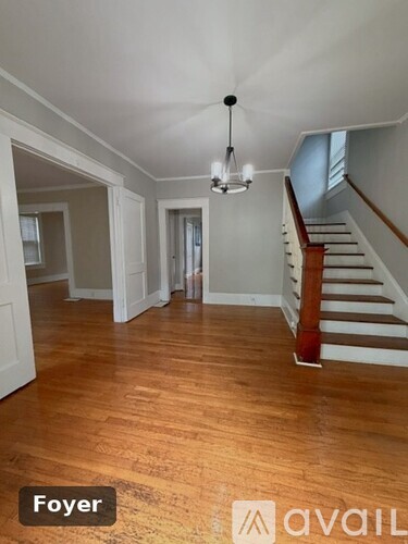 A Foyer with a wooden floor and a staircase.