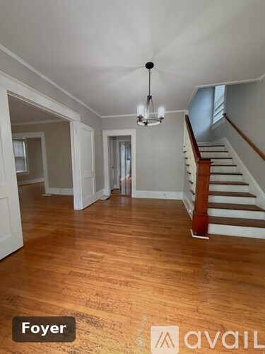 A Foyer with a wooden floor and a staircase.