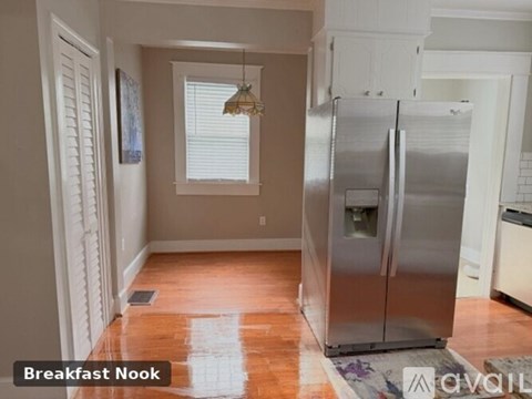 A kitchen with a refrigerator and a breakfast nook.