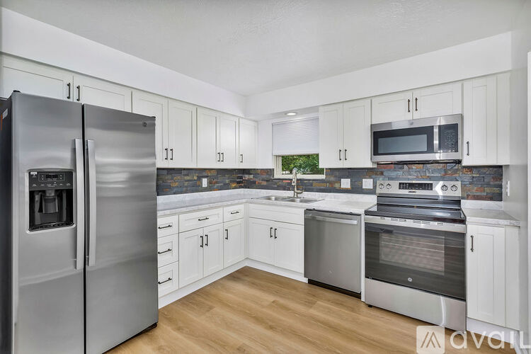 A kitchen with white cabinets and stainless steel appliances.