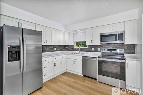 A kitchen with white cabinets and stainless steel appliances.