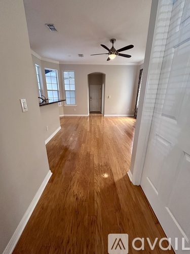 A room with wooden floors and a ceiling fan.