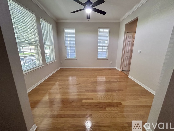 A room with wooden flooring and a ceiling fan.