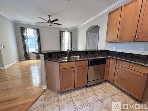 A kitchen with wooden cabinets and a black countertop.