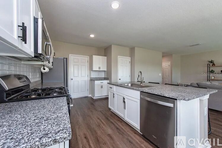 A kitchen with white cabinets and a patterned stove top.