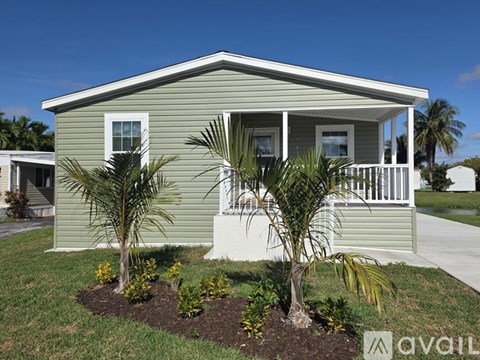 A house with a green exterior and a white porch.