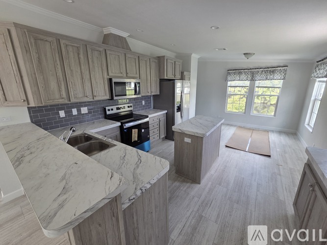 A kitchen with wooden cabinets and a marble countertop.