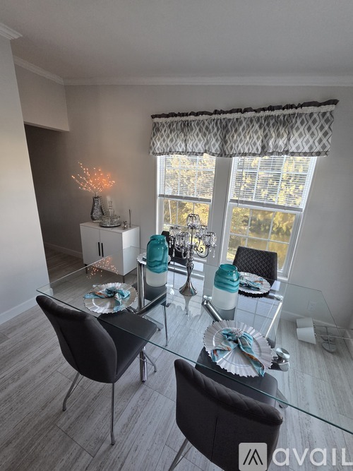 A dining room with a glass table and chairs.