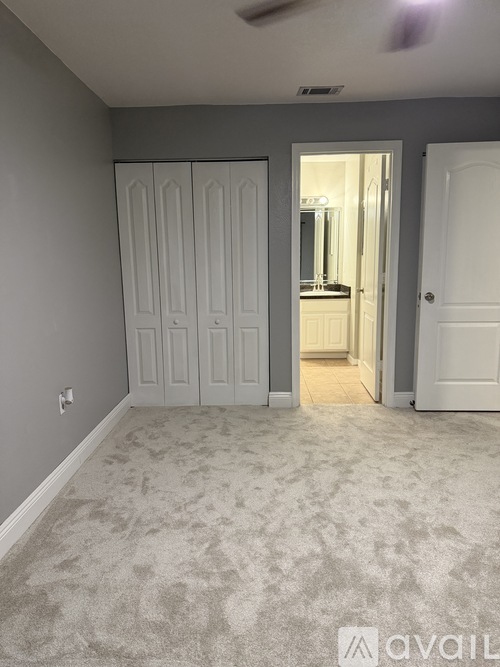 A room with a carpeted floor and a white door.