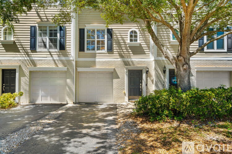 A two-story house with a tree in front.