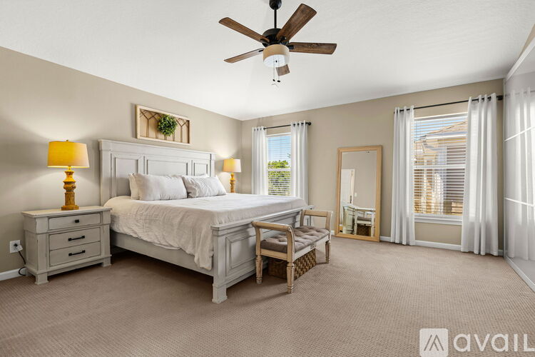 A bedroom with a bed, nightstand, and chair.