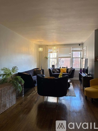 A living room with a yellow chair and a brown couch.