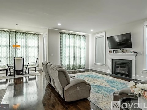 A living room with a fireplace and a television on the wall.