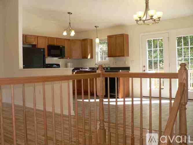 A kitchen with wooden cabinets and a black microwave.
