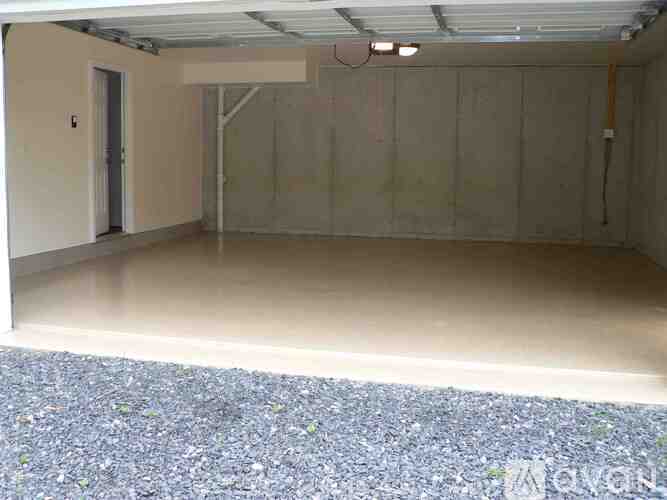 A sparsely furnished room with a concrete floor and a concrete wall.