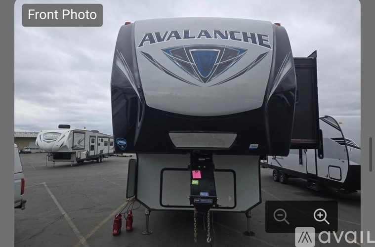 A silver Avalanche RV parked in a lot.