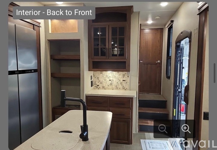 A kitchen with a refrigerator, sink, and cabinets.