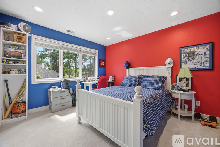 A bedroom with a white bed and a red wall.