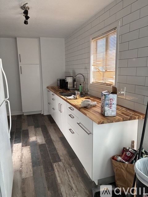 A kitchen with white cabinets and a wooden countertop.